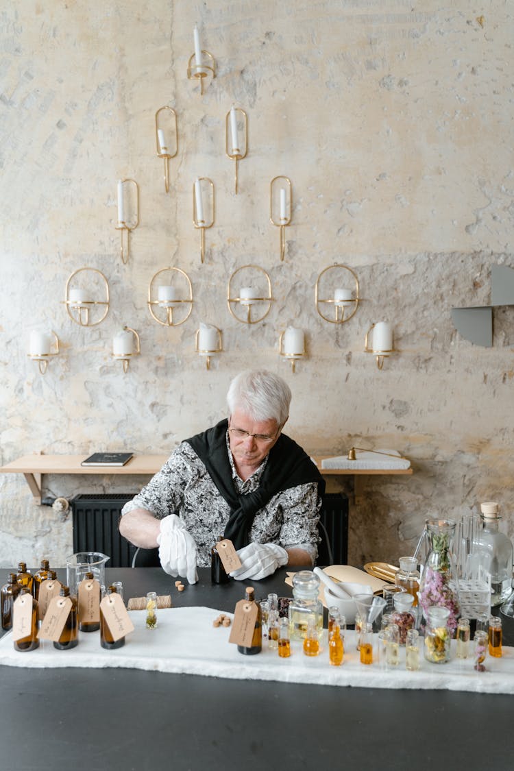 A Man Placing Tags On Bottles