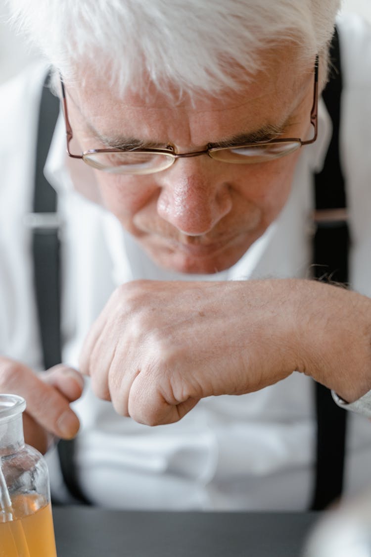 Close-Up Shot Of An Elderly Man Smelling His Hand