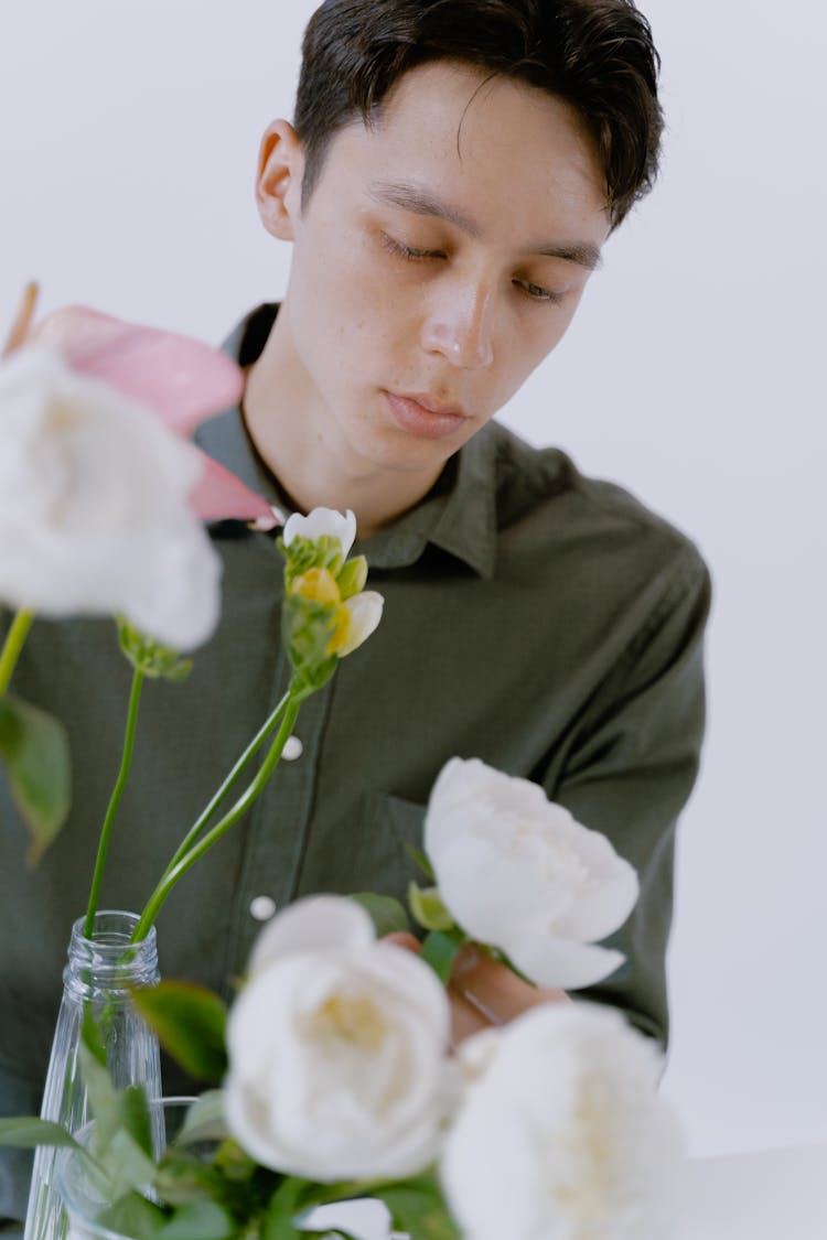 Man In Gray Button Up Shirt Holding A Flower