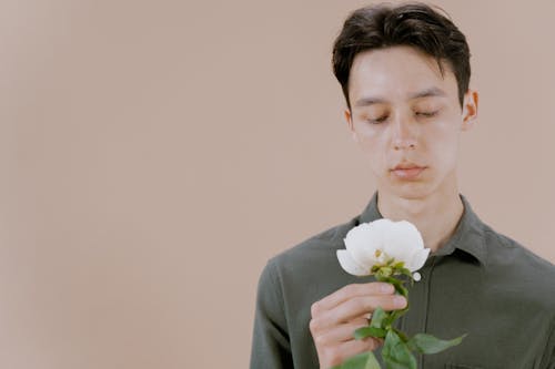 A Man Holding a White Flower