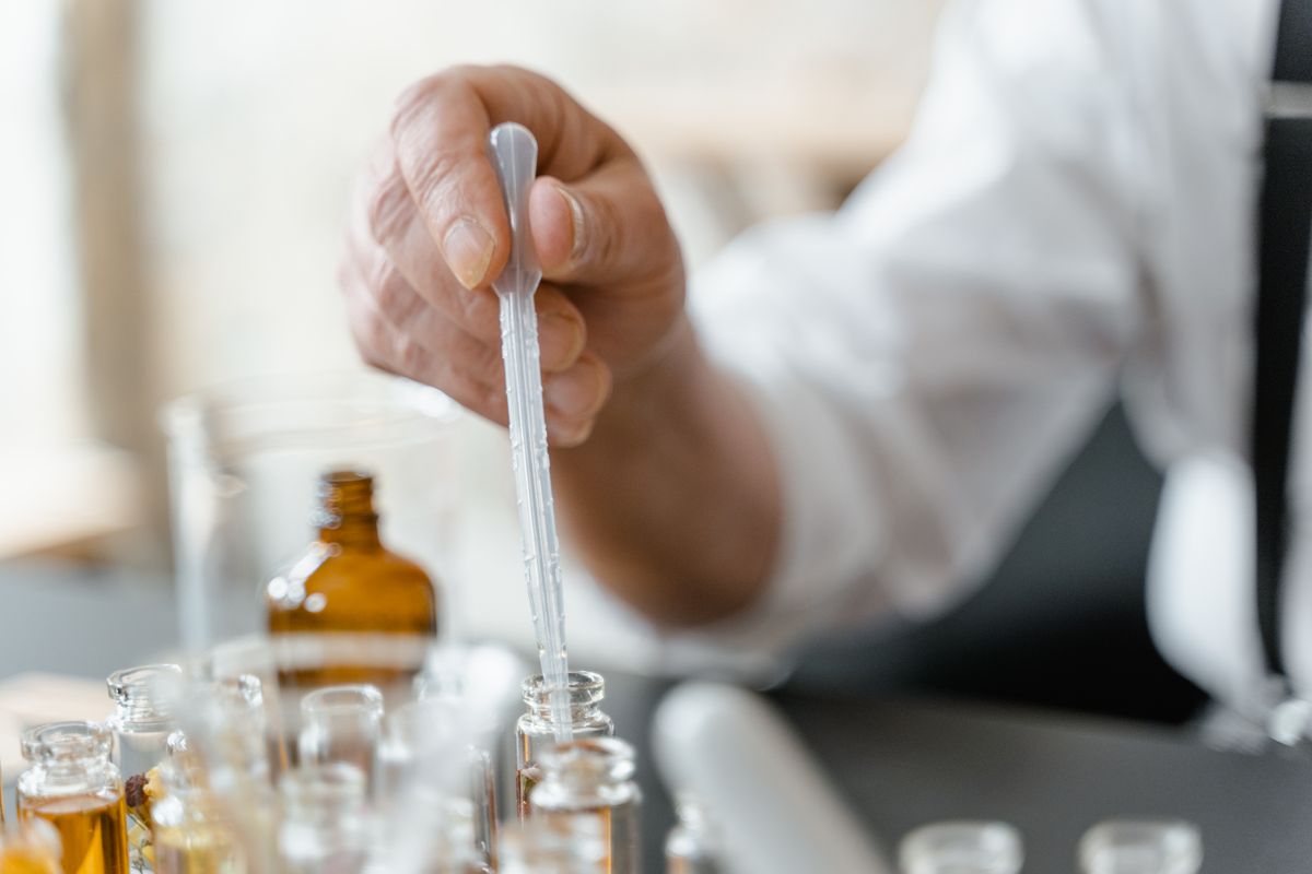 A formulator working with vials and a pipette in a development laboratory