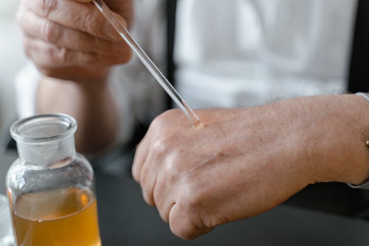 Close-Up Shot Of A Person Holding A Perfume Tester