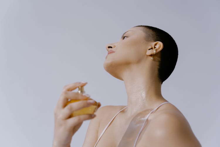 Woman Spraying Perfume On Her Neck