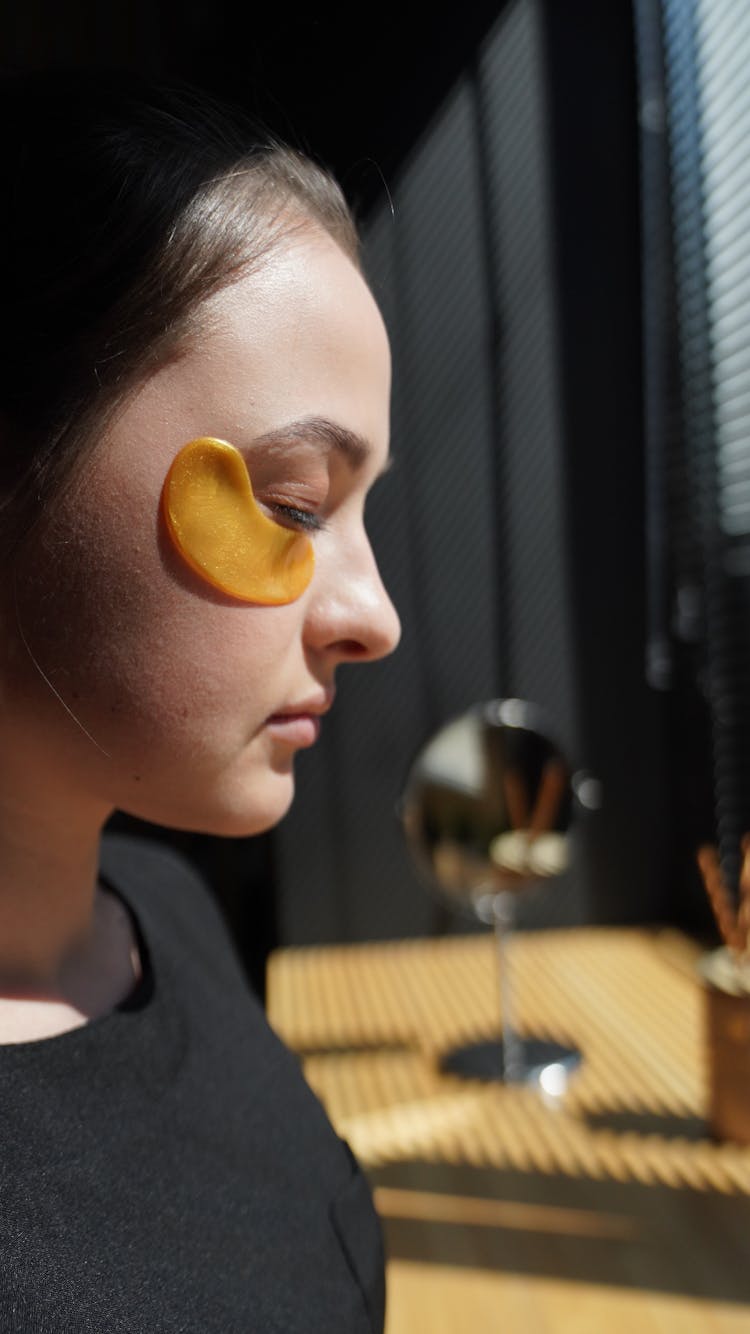 Adolescent Girl Wearing Cosmetic Pad Under Eye