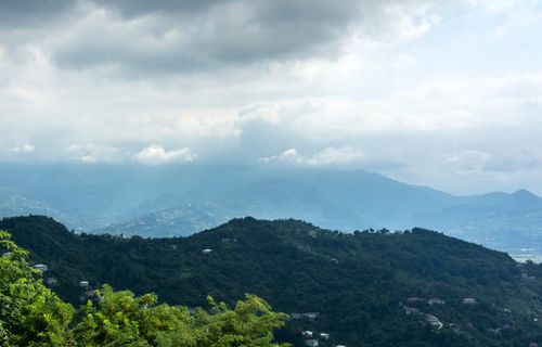 Free Breathtaking aerial view of lush green mountains shrouded in mist at dawn. Stock Photo