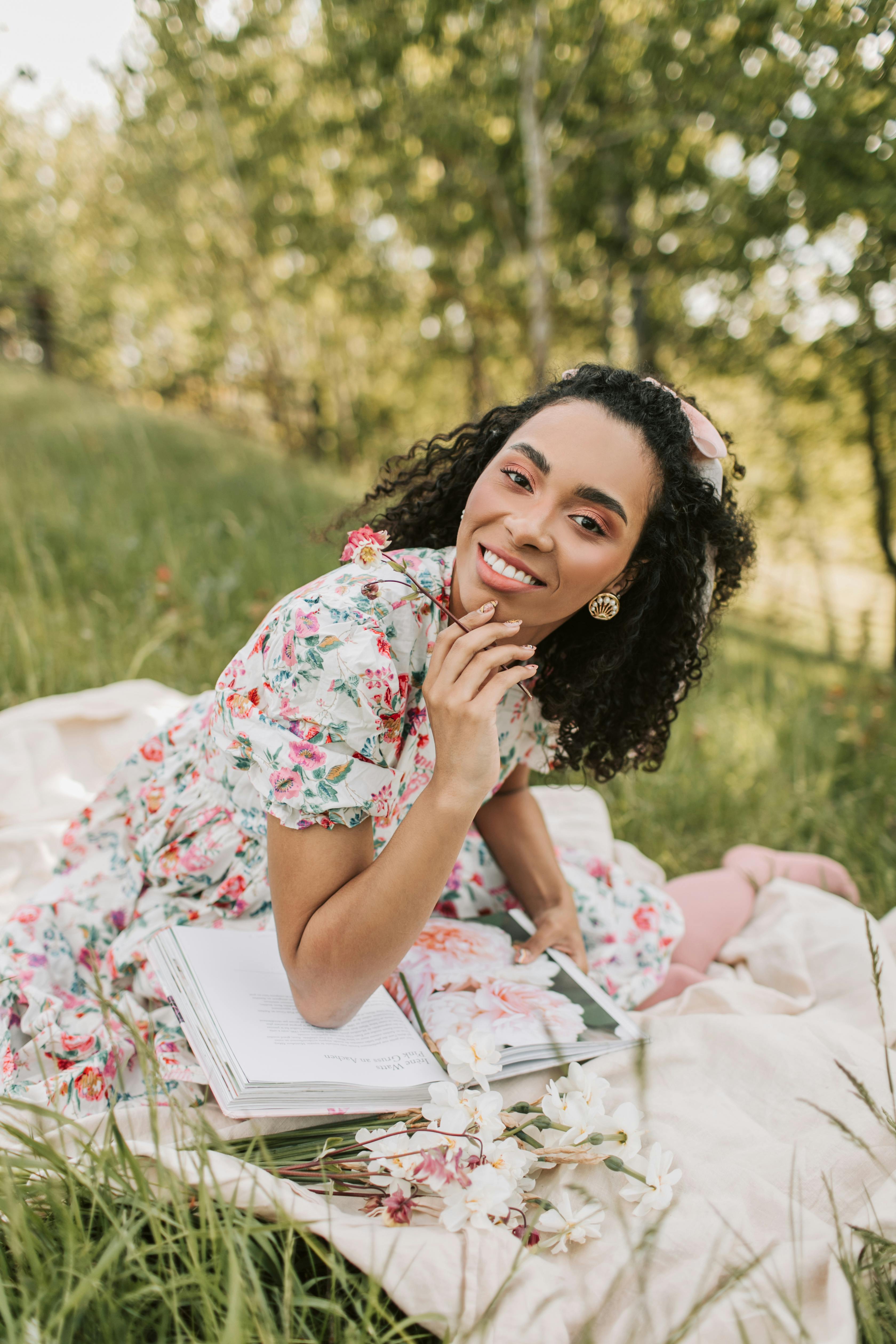 woman in floral dress sitting on a picnic blanket