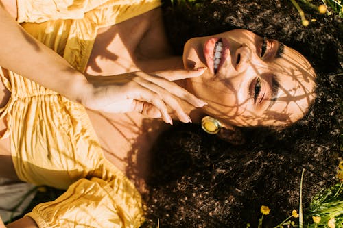 Free Woman Wearing a Crop Top Lying on Grass Stock Photo