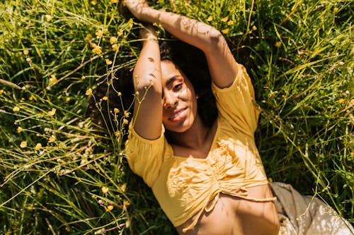 Woman in Yellow Crop Top Lying on Grass