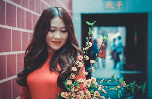 Mujer con vestido rojo y flores al aire libre