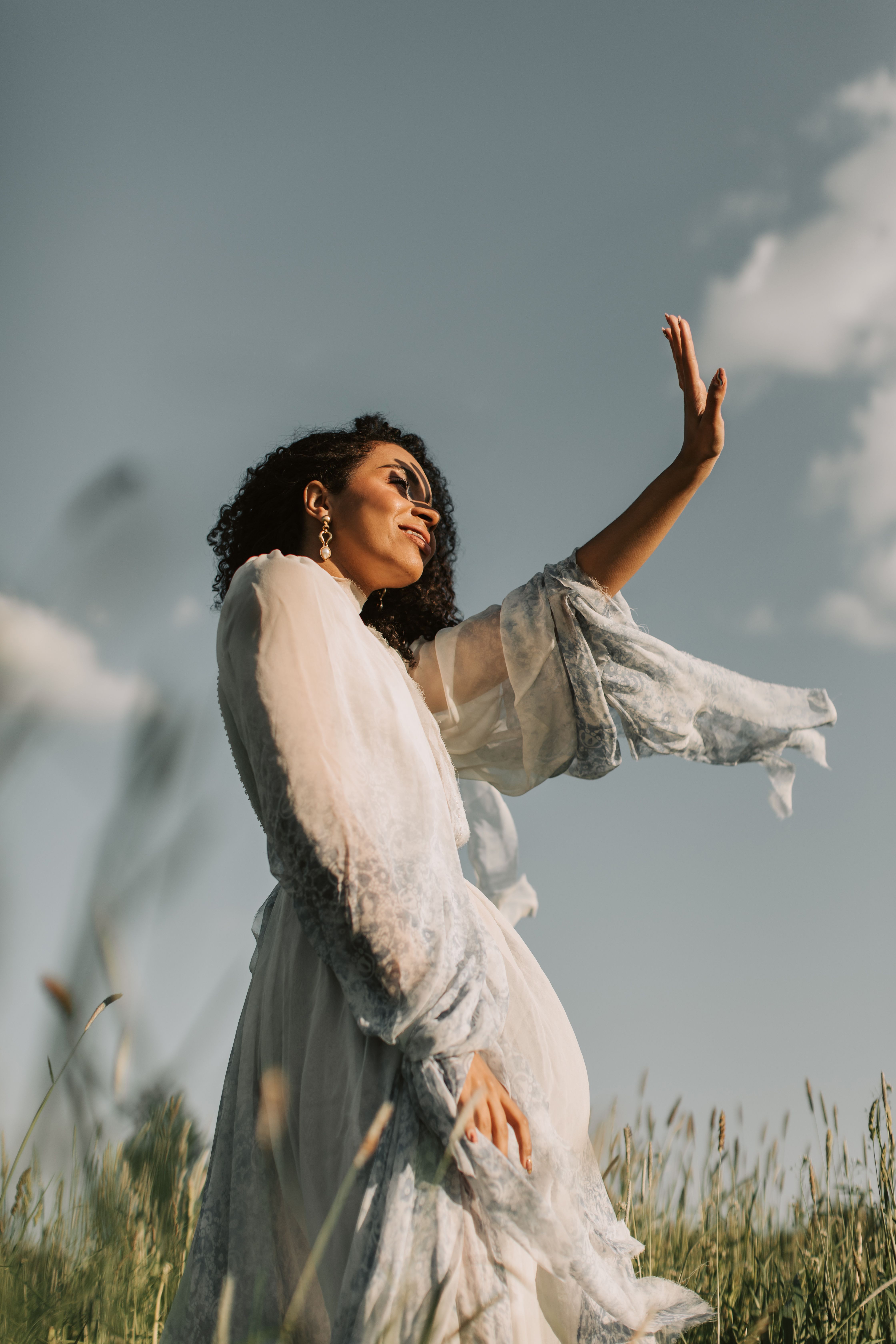 Woman in White and Red Floral Dress Standing on Green Grass Field ...