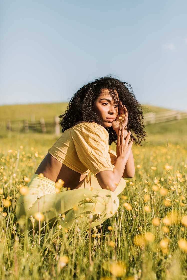 Woman Sitting On Yellow Flower Field