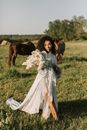 Woman in White Gown Standing Near Horses
