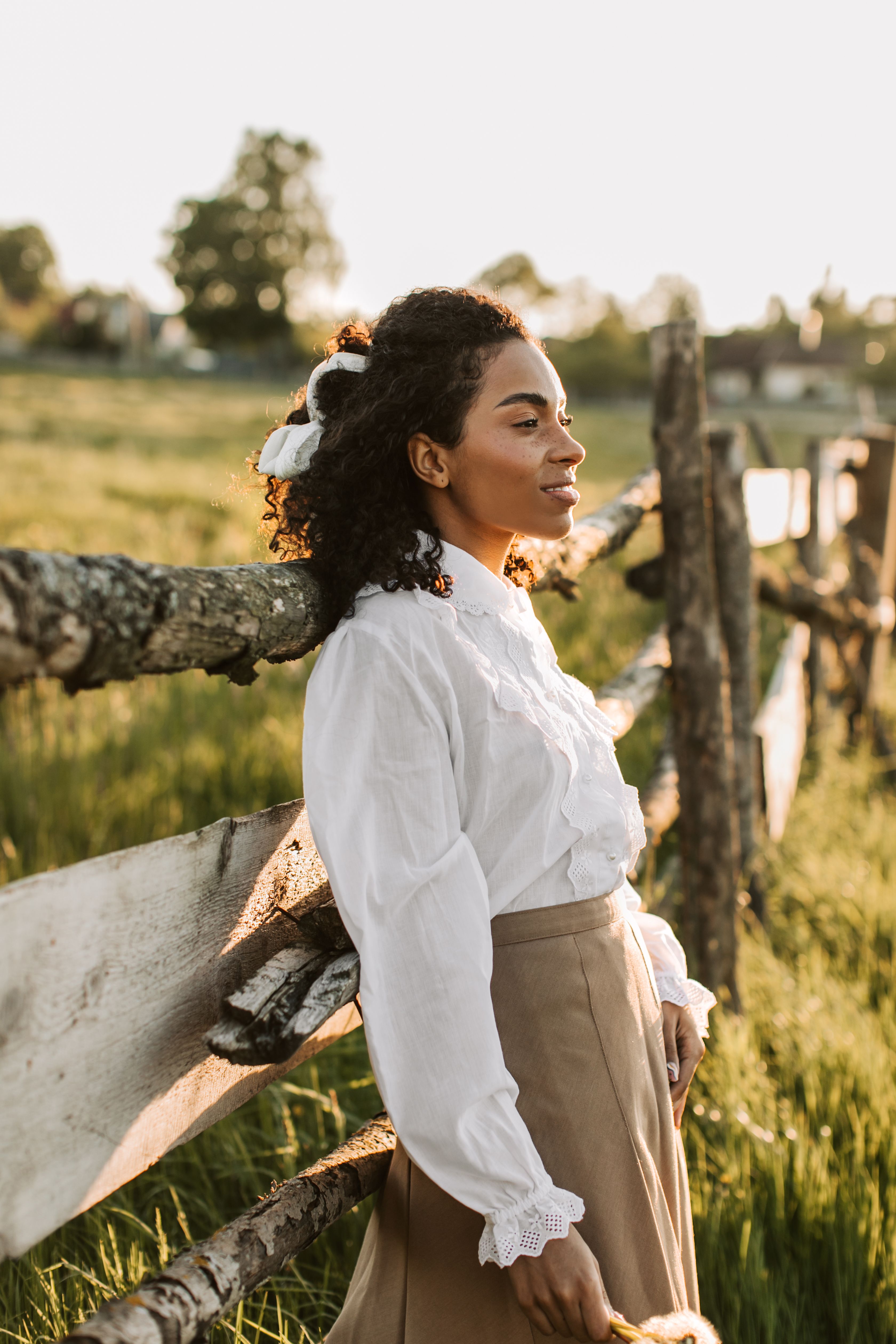 Woman in White Long Sleeve Shirt and Brown Skirt Leaning on Wooden ...