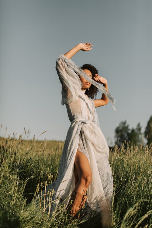 Woman in a Gray Dress in a Grassland · Free Stock Photo