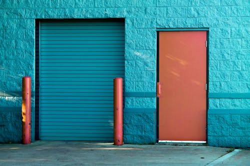 Free Brown Panel Door Near Roll-up Gate Stock Photo