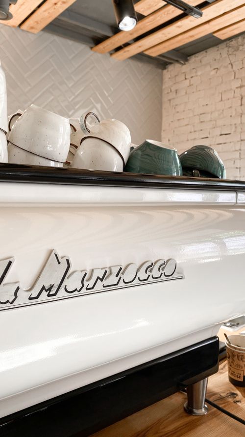 Free A stylish display of ceramic cups on a La Marzocco espresso machine in a modern cafe setting. Stock Photo
