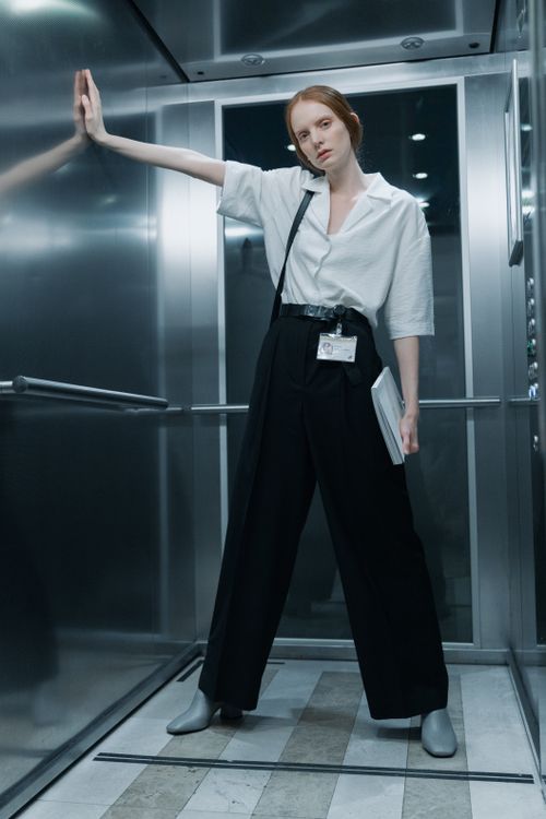 Woman in white button-down shirt and black pants office outfit with loafers