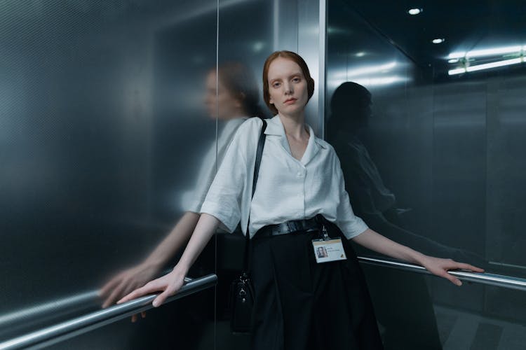 Woman Button Down Shirt Standing Inside An Elevator