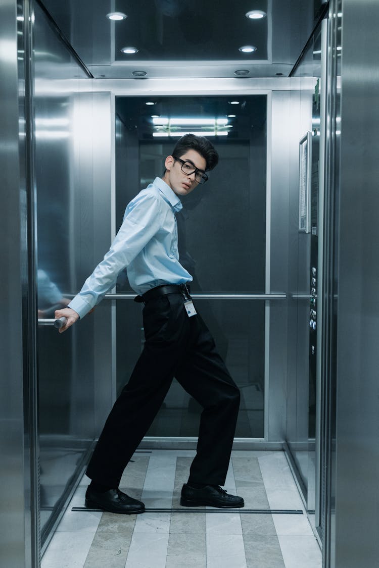 A Man In Black Pants Standing Inside The Lift