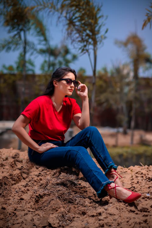 Woman wearing red camisole sitting near the house photo – Free Footwear  Image on Unsplash