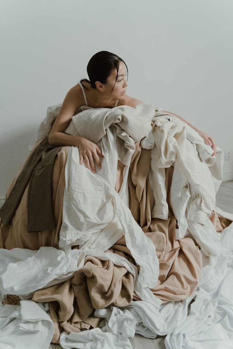 Woman In A Pile Of Fabrics