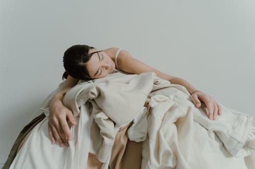 Woman lying in a Pile of Clothes