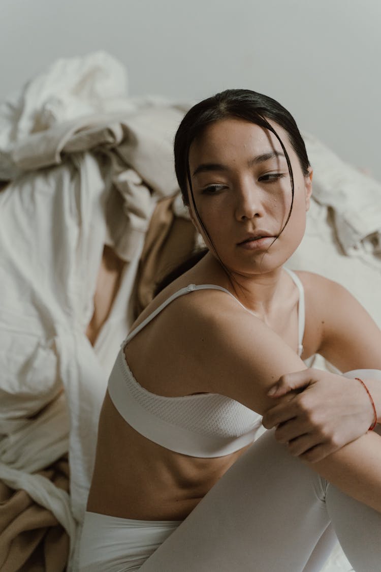 Woman Sitting Near Pile Of Clothes