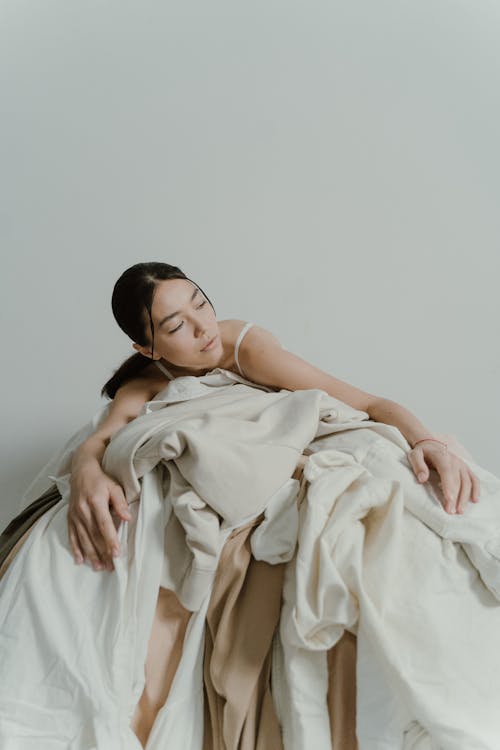 Woman lying in a Pile of Fabric