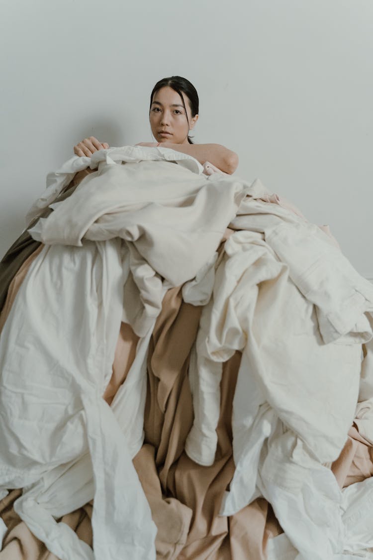 Woman On Top Of Heap Of Clothes