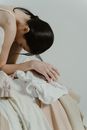Woman with her Head Down in a Pile of Fabrics