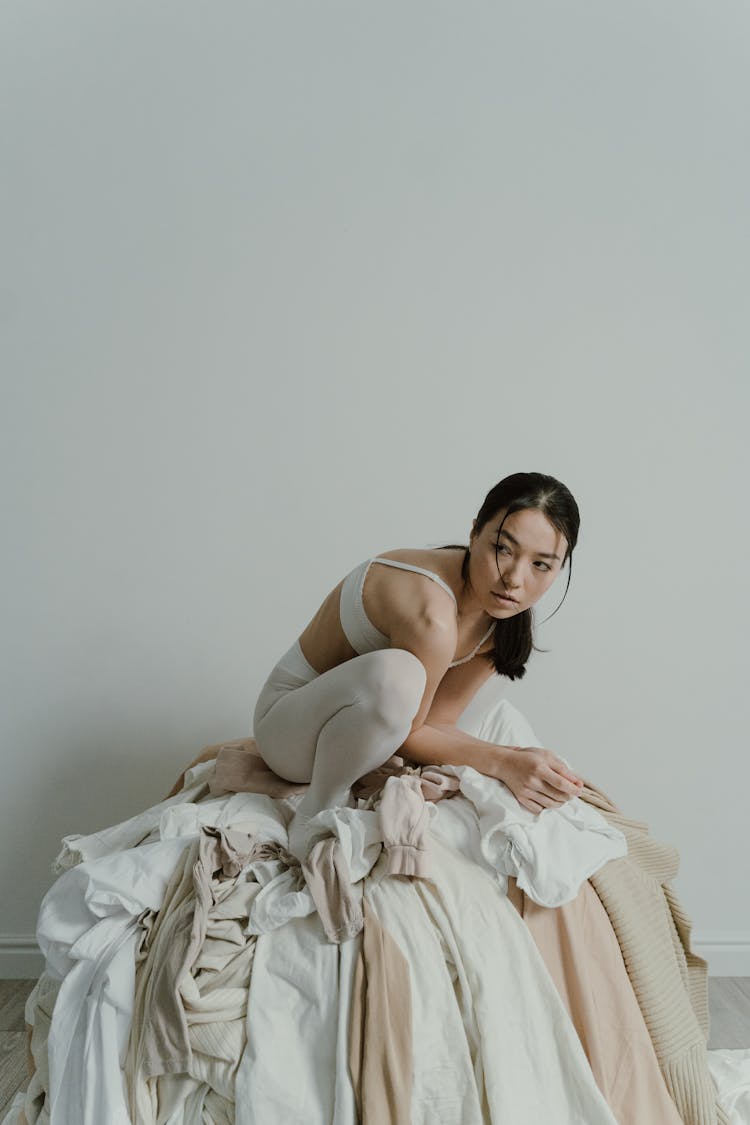 Woman Sitting On Top Of The Pile Of Clothes 