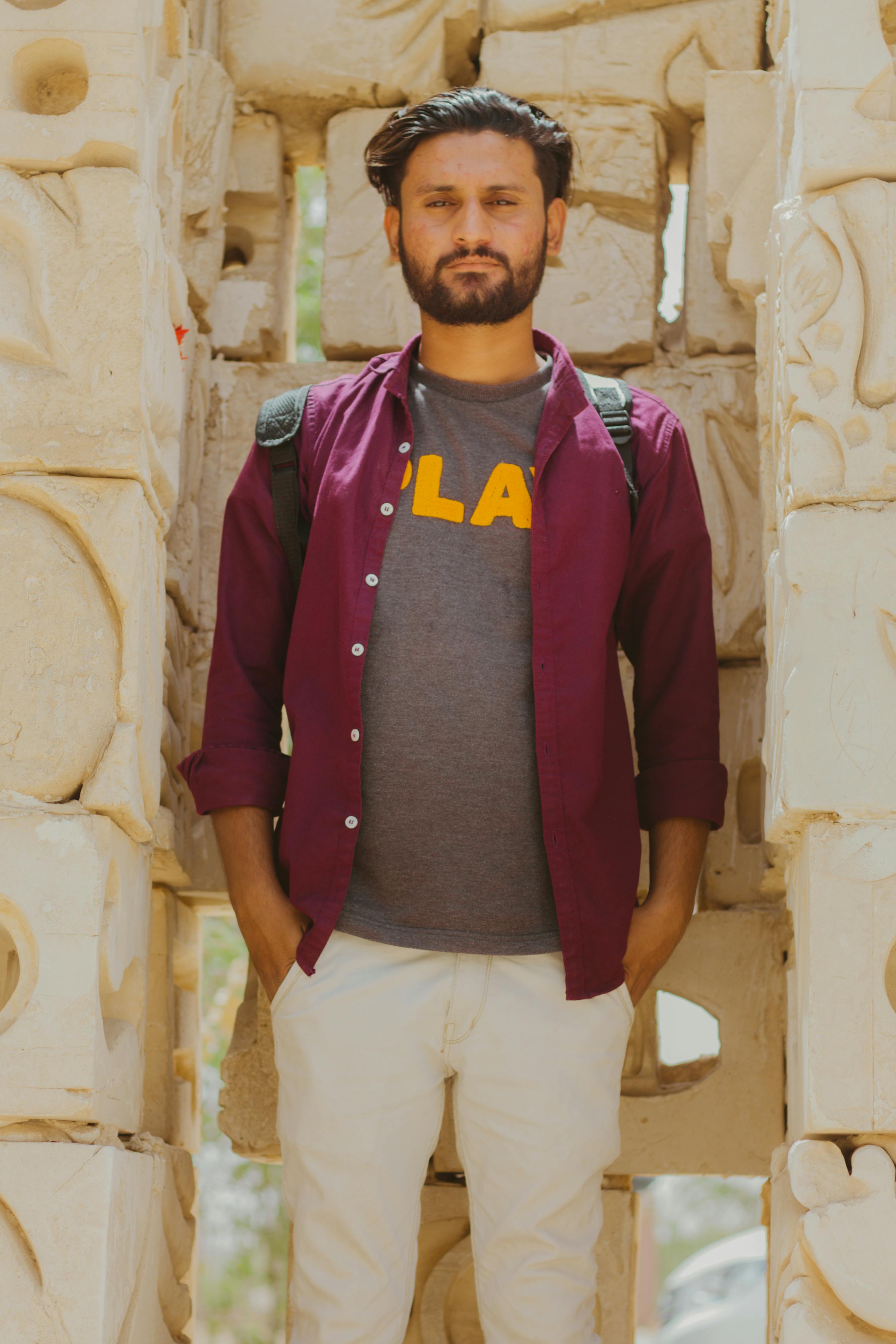 De franc Un Home Amb Camisa Morada Que Porta Una Motxilla Foto d'estoc