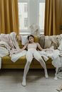 Woman Sitting On The Couch With Unorganized Clothes