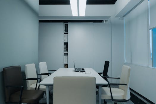 Modern conference room with minimalist design and neutral color palette, showcasing simplicity in workspace.