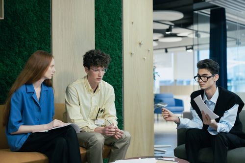 Free A diverse group of young professionals discussing work in a modern office setting. Stock Photo