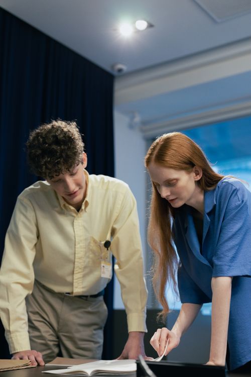 Free Two colleagues engaged in a work discussion at the office table. Stock Photo