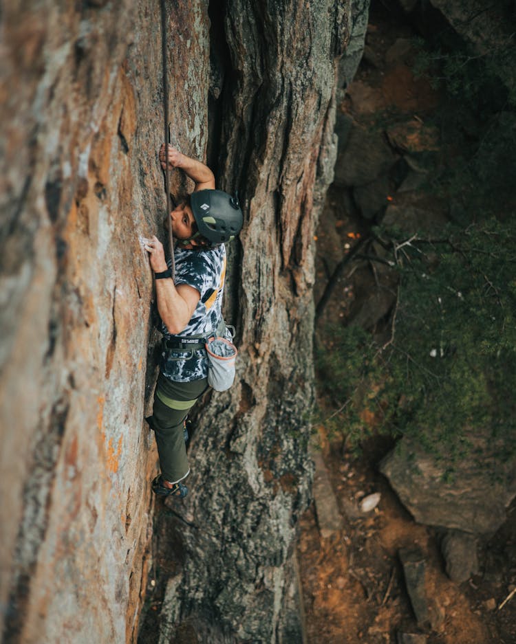 Man In Black Helmet Climbing On Rock