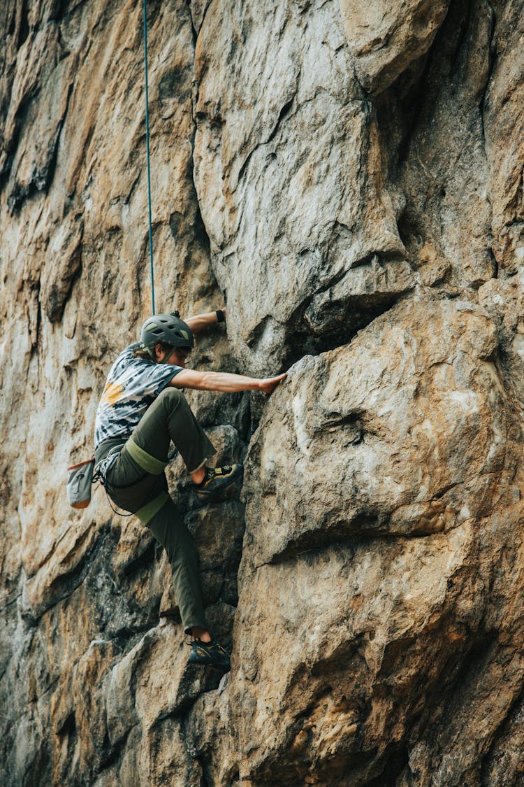 Man In Black Helmet Climbing On Rock