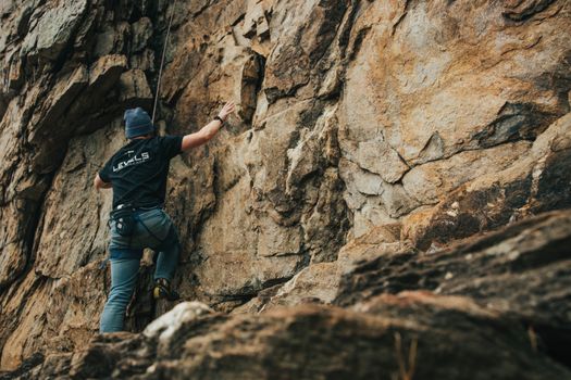 A climber on a rocky cliff in Gastonia, NC, showcasing outdoor adventure and extreme sports.