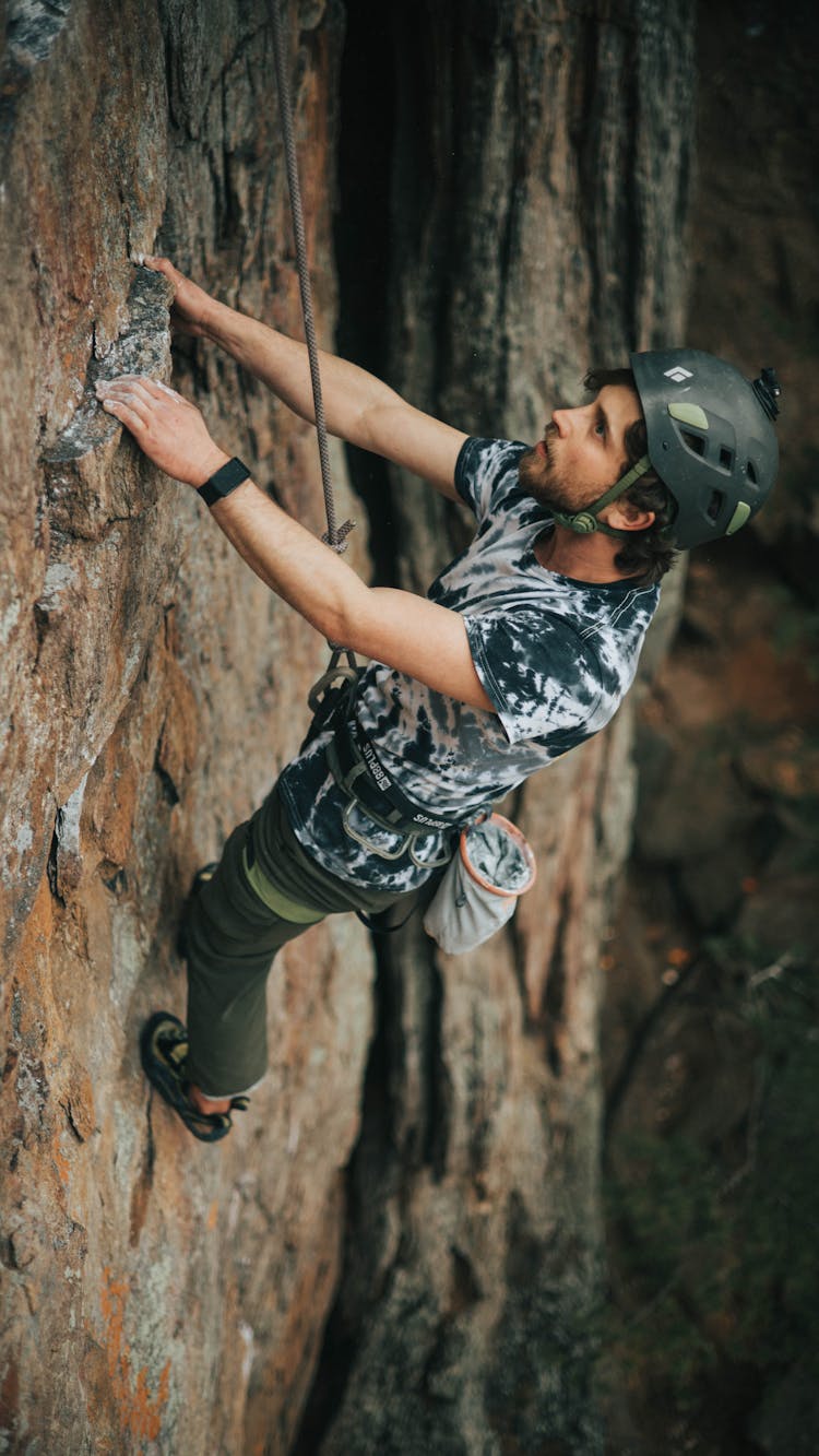 Man In Black Helmet Climbing On Rock