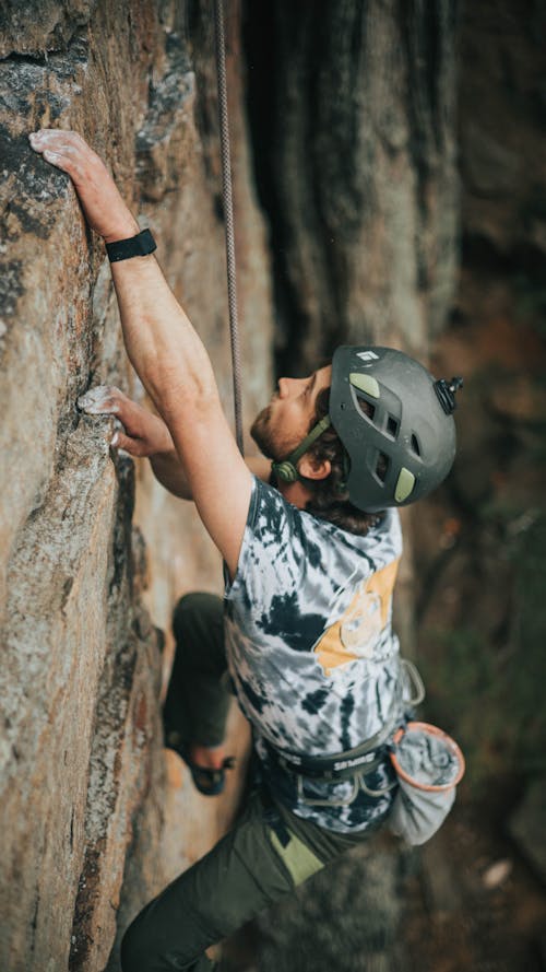Man in Helmet Climbing on Rock