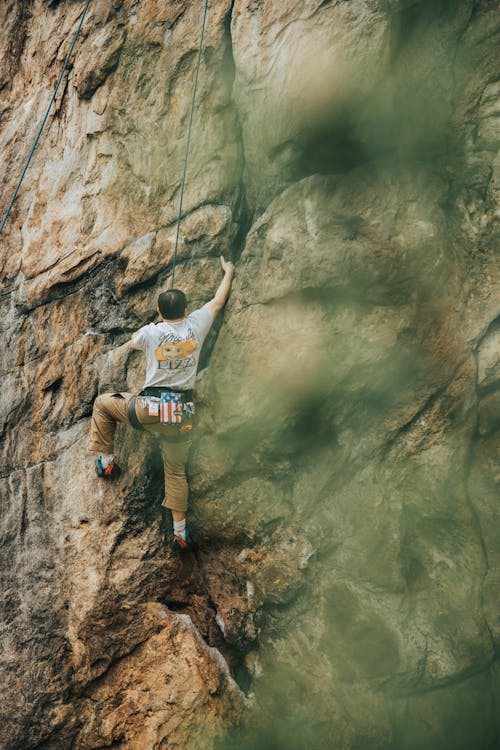 Man in Gray T-Shirt Rock Climbing