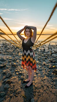 Elegant woman standing on a rocky beach during sunset in Victoria, Canada