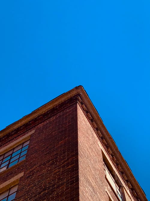 Free Low Angle Shot Of a Brown Brick Building  Stock Photo