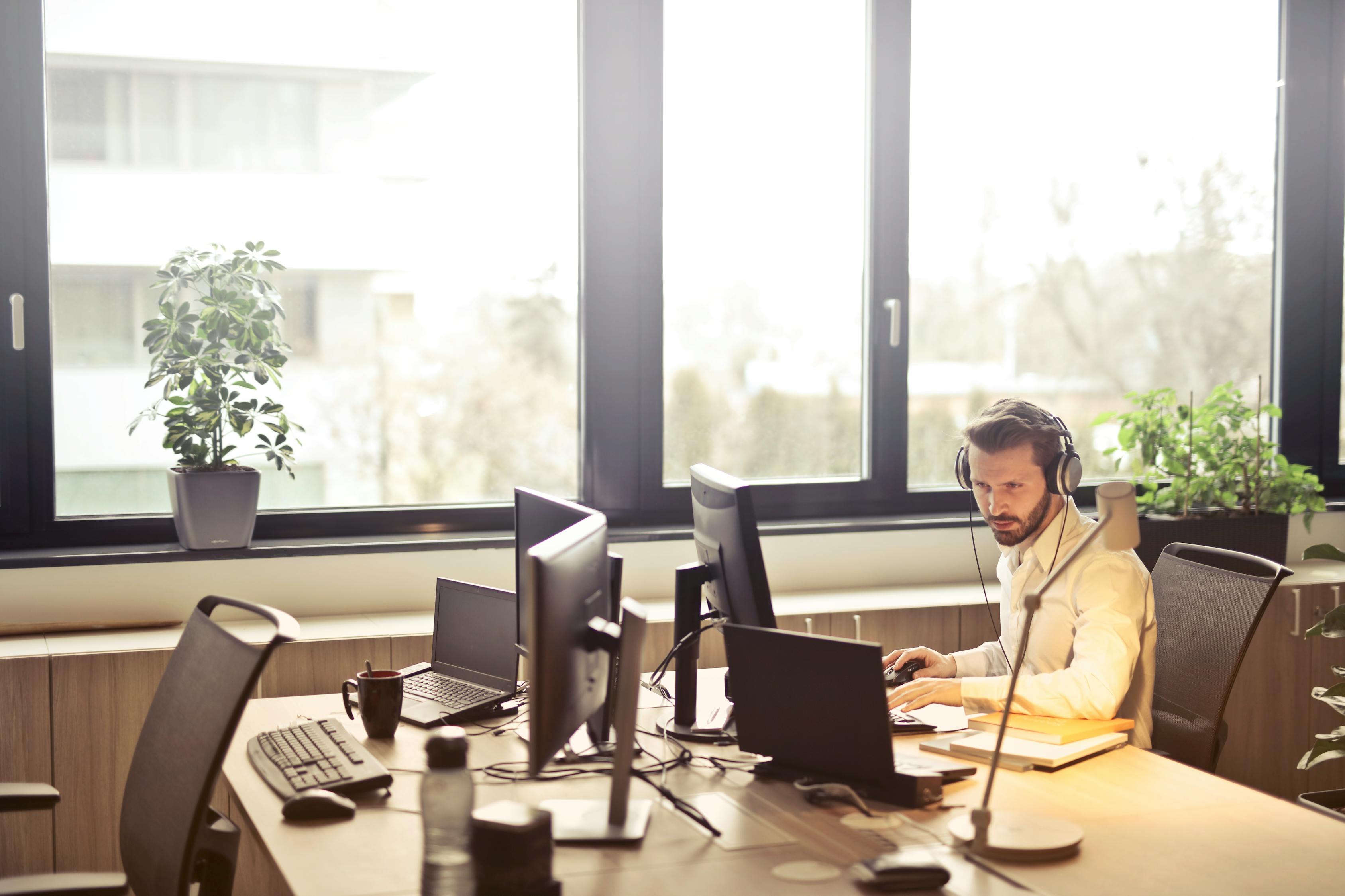 Hombre Con Auriculares Frente Al Monitor De La Computadora