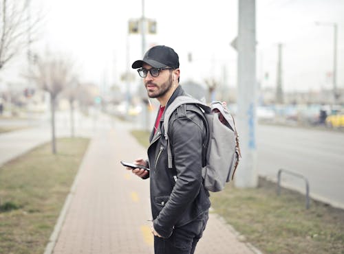 Uomo Che Indossa Una Giacca Di Pelle Nera Che Tiene Smartphone