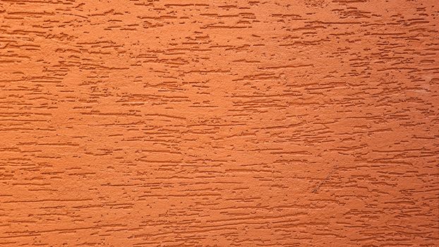 Close-up of an orange textured wall surface in Campinas, Brazil, showing a rough pattern.