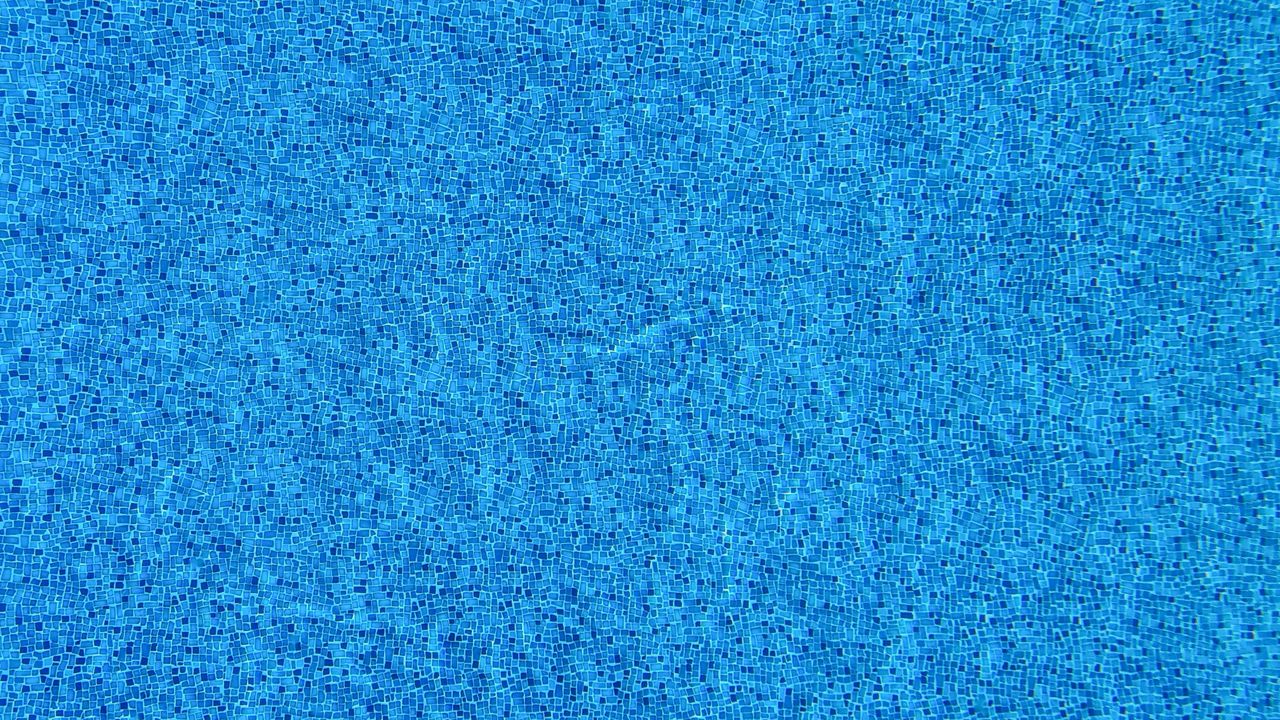 close up view of blue mosaic tiles covering a swimming pool surface