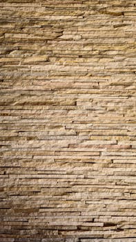 Close-up view of a textured stone wall showcasing linear patterns and natural colors.
