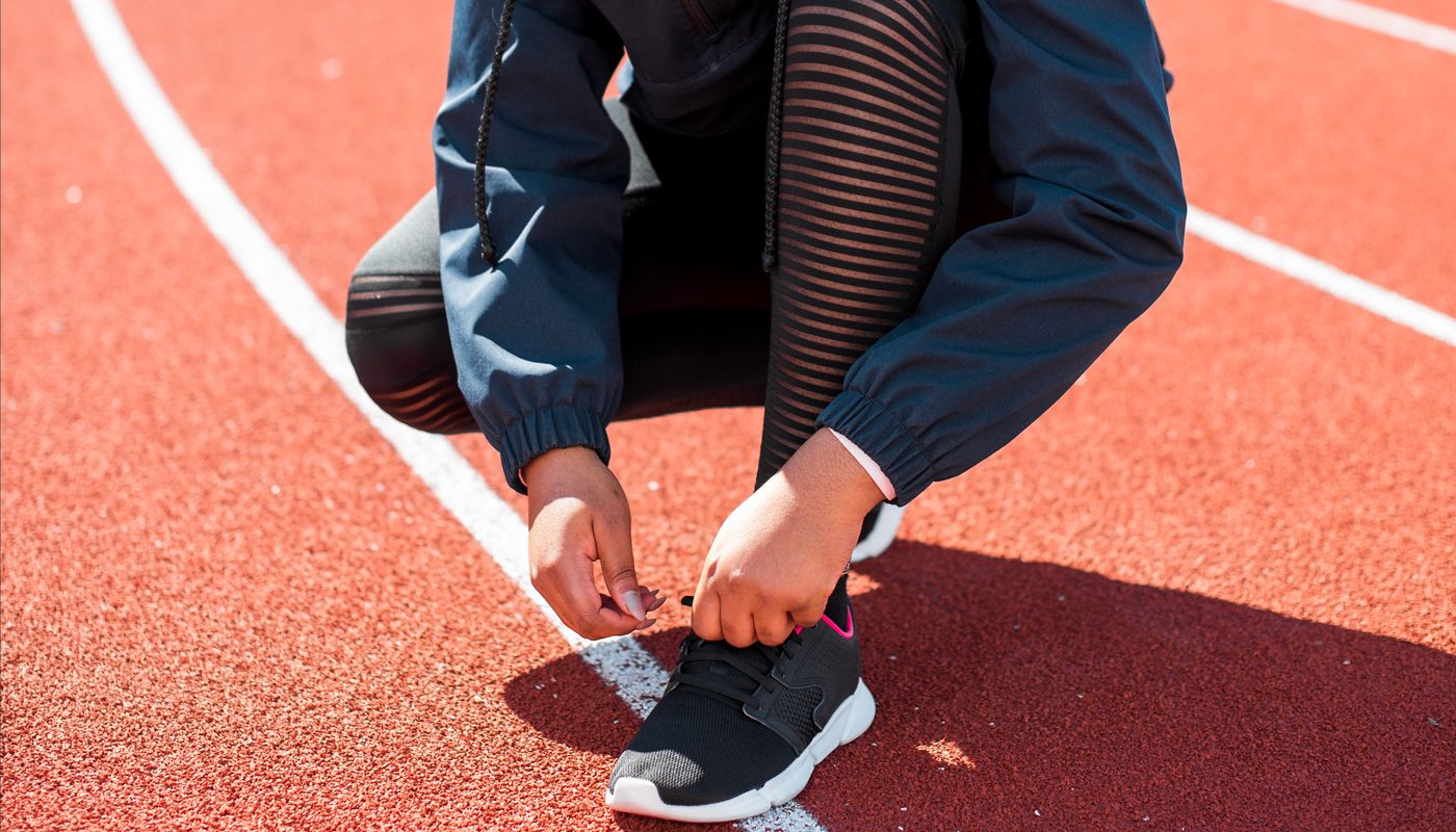bodyweight workout challenge — Person Tying a Shoe on a Track · Free. Photo: Pexels